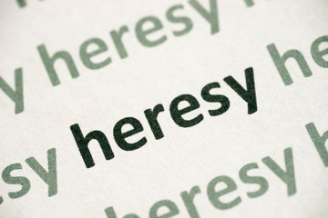 word heresy printed on paper macro