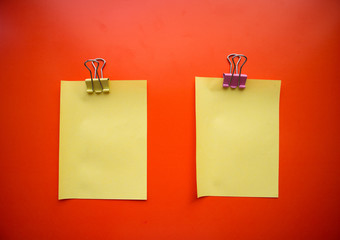 Сolorful blank sticky note or empty post notes with office clamps on red background