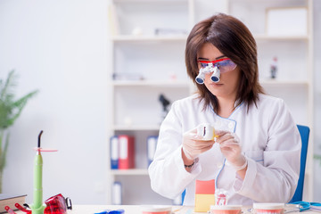 Woman dentist working on teeth implant