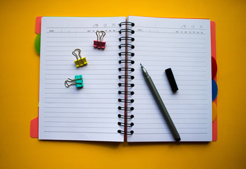 Сolorful blank sticky note or empty post notes with office clamps and notebook on yellow background