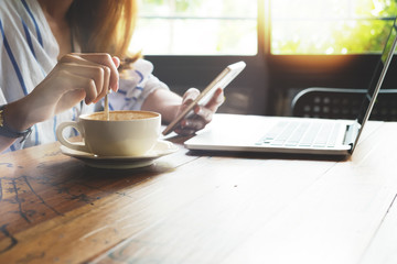 Hipster woman using mobile laptop. young businesswoman working at coffee shop. freelance worker concept. Film color tone. Flares and light effect background.