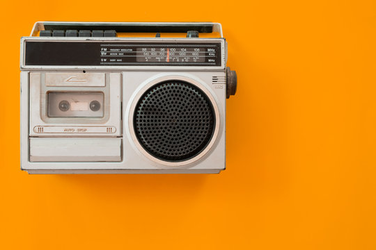 vintage radio and cassette player on colour background, flat lay, top view. retro technology
