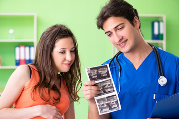 Pregnant woman visiting male gynecologyst at the clinic