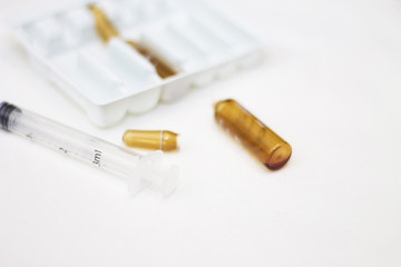 Empty medical ampoules infusion and used syringe after injection isolated on white background