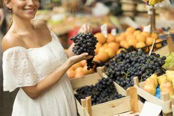 Young woman buying fruits on the market