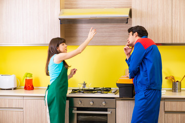Woman with contractor at kitchen discussing repair