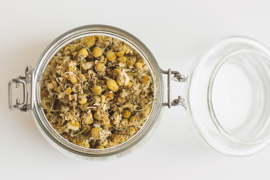 Jar with dried chamomile flowers. Herbal tea, top view