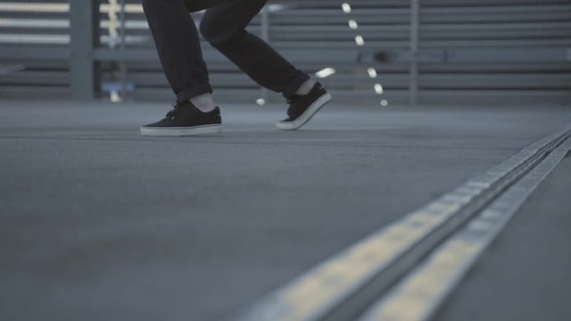 Urban dancer on a roof top environment, Close up feet on grey concrete floor