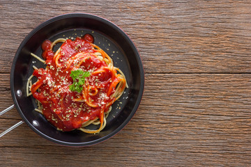 Spaghetti with tomato sauce on rustic wooden table , top view, copy space.