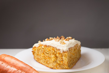 Piece of carrot cake on plate with copy space on background