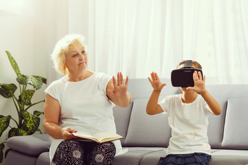 Senior woman using virtual reality glasses with her granddaughter