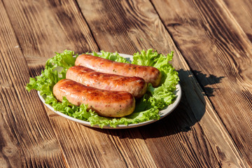 Grilled sausages on wooden table