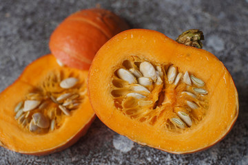 Fresh organic pumpkin in slices on dark stone table. Autumn harvest, healthy lifestyle, raw vegetables, selective focus. Halloween background