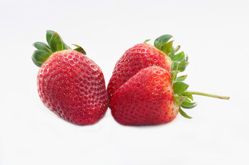 Three red ripe strawberries on gray