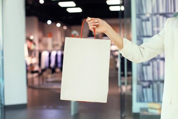 woman hand hold shopping bag at clothes store.