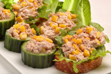 Toast and cucumber appetizers with tuna paste and corn