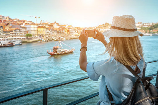 Happy blonde woman - tourist shot on her smartphone camera in Porto Portugal