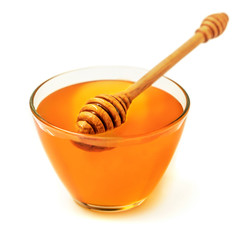 Honey bowl with honey dipper isolated on white background. Close up.