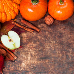 Harvest or Thanksgiving background with pumpkins, apples and fallen leaves on wooden background  with copyspace. Halloween, Thanksgiving day or seasonal autumnal concept.