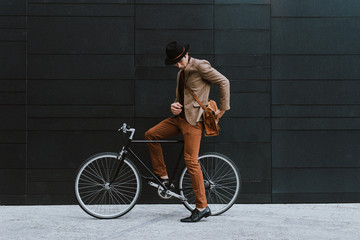 Handsome young business man with his modern bicycle. - Powered by Adobe