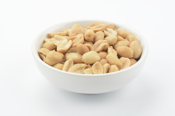 Cacahuetes pelados fritos en un bol de cerámica blanca sobre fondo blanco