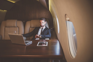 Businessman flying on his private jet. Business man flying on the private airplane. Working during...