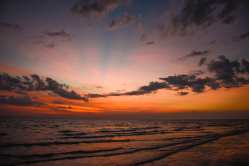 Nature in twilight period which including of sunrise over the sea and the nice beach. Summer beach with blue water and purple sky at the sunset.