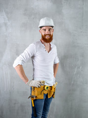 bearded brutal architect, engineer builder smiling at the background of a concrete wall