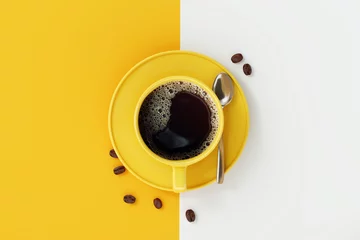 Draufsicht der Kaffeetasse auf gelbem und weißem Hintergrund. © aanbetta