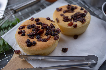 Cook preparing a sweet cake topping with raisin on it