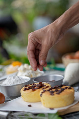 Cook preparing a sweet cake topping with raisin on it