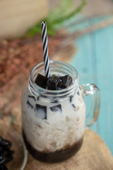 Glass of Fresh milk and Black grass jelly on top