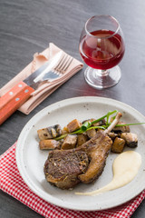 Lamb rack steak and mushroom put on the white dish with red wine.