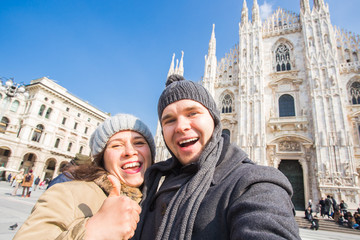 Couple taking self portrait in Duomo square in Milan. Traveling and relationship concept