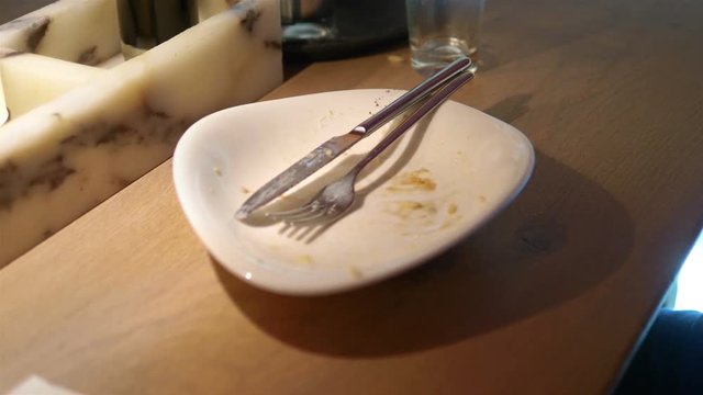 Throwing napkin on thirty plate after eating in 4k slow motion