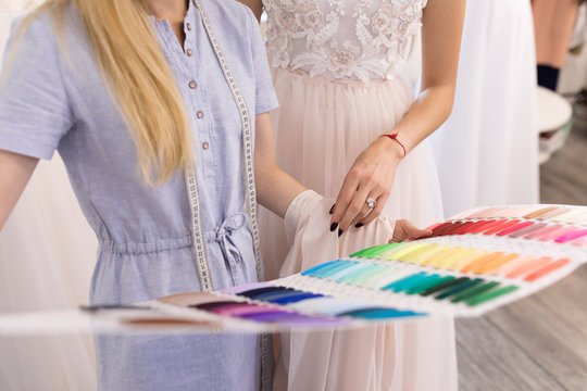 Fitting A Wedding Dress In The Office Of A Seamstress And Choose The Color Of The Fabric For The Dress. The Bride And The Designer Of Wedding Dresses Try On A Dress