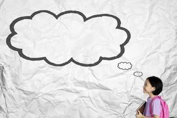 Happy schoolgirl looks at an empty cloud bubble