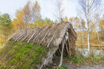 Hut in the forest in autumn at a lake