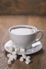 cup of cocoa drink with marshmallow on oak wood table