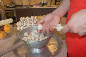 hands only view of oman in apron, preparing for a healthy organic vegetarian meal with mushrooms...