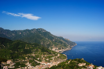 Fototapeta na wymiar Small Italian villages in the covered with greenery mountains of Amalfi coast. Shot from Ravello on a sunny day 