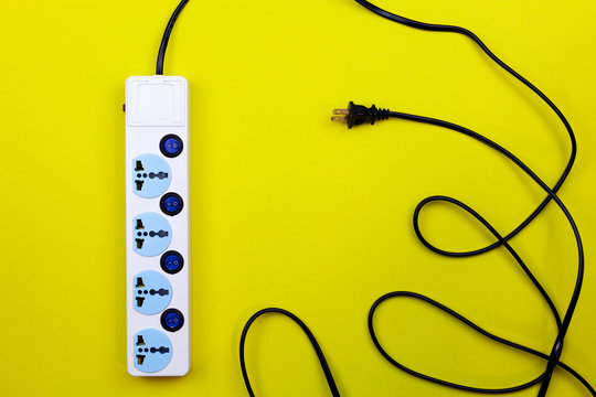 Electric power socket and plug on yellow paper background.