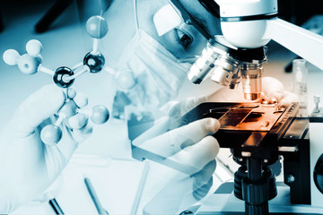 Close up of microscope viewing sample with atom ball and stick molecular model for research, learn, work, solution in chemistry laboratory.