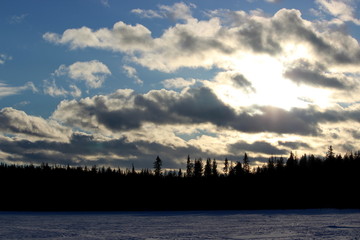 midnight sun over frozen lake in lapland, finland