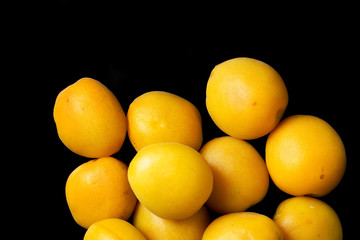 Ripe apricot on a black background, top view.