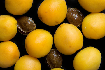 Ripe apricot on a black background, top view.