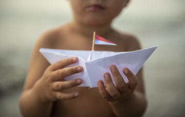 Kleines Papierboat in der Hand eines Kleinkindes