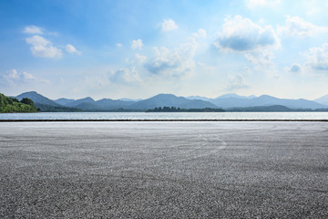 Empty asphalt square and mountain with lake on a sunny day