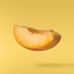 Flying fresh ripe peach with green leaves isolated