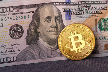 Beautifully arranged bills 100 dollar and gold coin bitcoin on a gray background. Bitcoin cryptocurrency. Anonymous. Background for your text and design